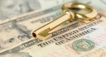 A key lies on top of money.
