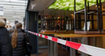 People walk past a closed business.