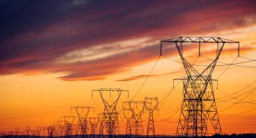 Power lines and transmission towers against a sunset.
