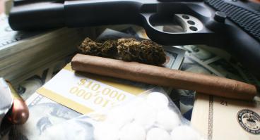 Drugs and a gun with money in a pile
