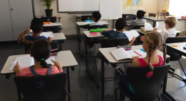 Children sit at desks in school