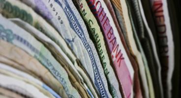 International paper currencies stacked together, showing range of colors and styles
