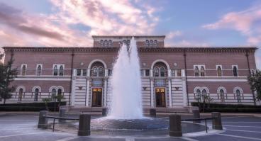 The front of Baker Hall, from across the plaza, with fountain in foreground