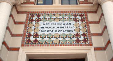 Tile mosaic over an entrance to Baker Hall that reads "A Bridge Between the World of Ideas and the World of Action"