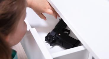 Small child reaches into drawer with firearm