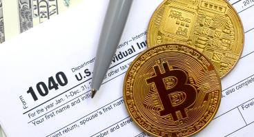 Bitcoins lie on an income tax form.