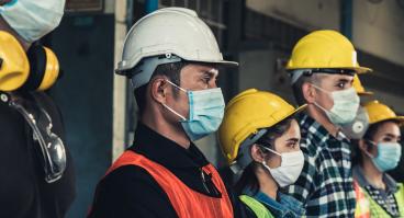 Construction workers wear masks.