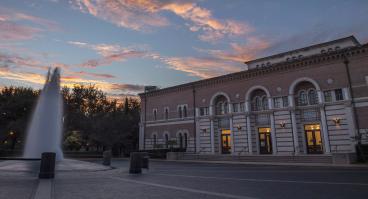 The front of Baker Hall, from across the plaza, with fountain in frame
