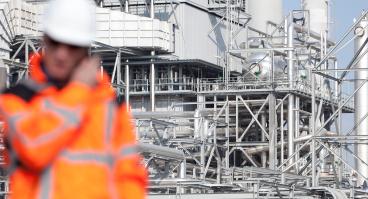 Inspector with refinery facility in background