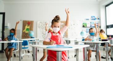 Young students wear COVID masks in the classroom