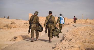 Several soldiers of Israel army walking with Israel national flag