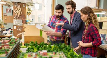 Landscape designers having discussion about city layout model 