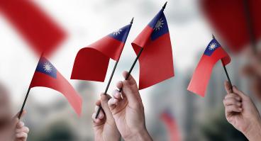  A group of people holding small flags of the Taiwan in their hands