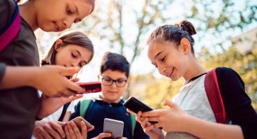  Kids playing video games on smart phone after school