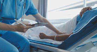 Physician holds patient's hand while encouraging and providing medical advice.