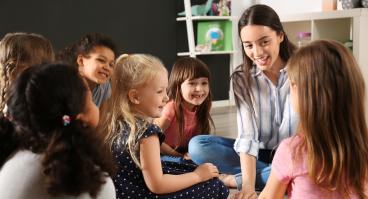 Children with nursery teacher in kindergarten
