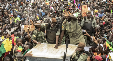 Members of the Malian junta wave as civilians gather to celebrate the overthrow of the president on Aug. 21, 2020.