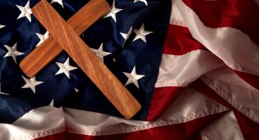  a wooden cross on the american flag