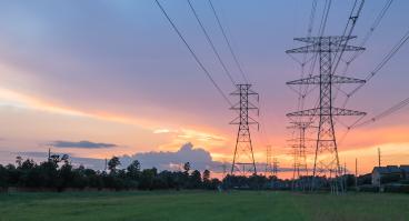 Group silhouette of transmission towers at dusk