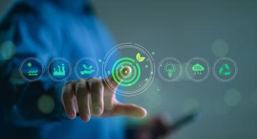 Business person touches a virtual screen displaying icons like renewable energy, co2 emissions reduction, green production, waste recycling, and solar power.