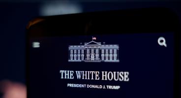 A smartphone screen displays the White House website and the official White House logo.