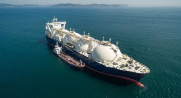 A small tanker on the roadstead bunkers a large LNG tanker