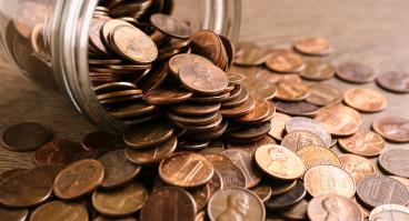 Glass jar with coins on table