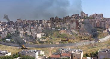 Israel and Palestine divided by wall with smoke and fire pisgat zeev and anata refugees camp, Jerusalem Israel-Aerial view