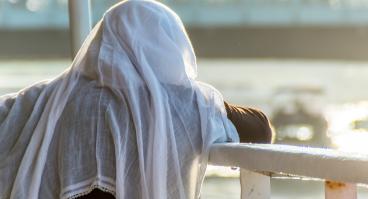 Licensed Find Similar File #:  94934002 Muslim woman on the fence of a boat overlooking the sea at sunset