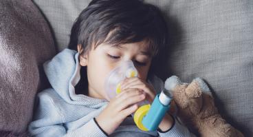 child using asthma inhaler