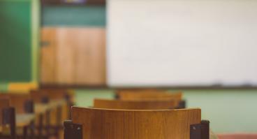 Lecture room or Examination room.School empty classroom with desks and chair.