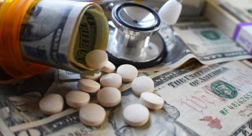 Pill bottle with pills and dollar bill rolls inside