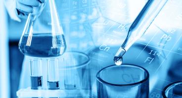 Hand of scientist holding flask with lab glassware and test tubes in chemical laboratory background.