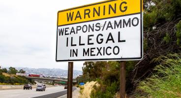Road sign near U.S.-Mexico border that says "Warning: Weapons/ammo illegal in Mexico"