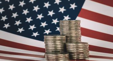 stacks of metal money are on the American flag. Financial system city concept. US coins and American flag 