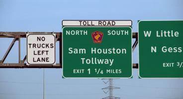 City traffic sign over the streets Sam Houston Tollway 