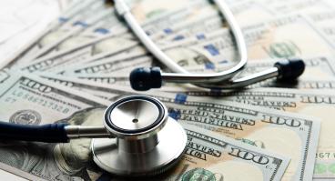 Stethoscope on top of U.S. bills