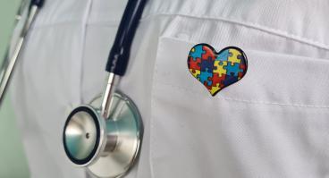 A Doctor Wearing a Stethoscope and a Puzzle Piece Heart Pin.