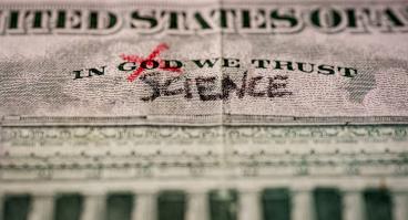 Word God crossed out and replaced by science on a US dollar bill. 