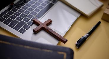  Cross on bible with headset and laptop in online study bible concept.