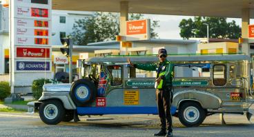 Traffic officer manages jeepney at petrol station
