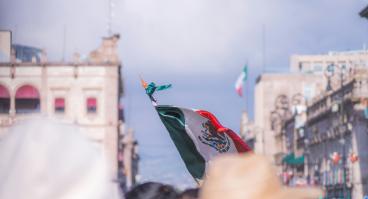 Foto de la bandera de México entre la gente en el centro histórico de Morelia.