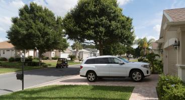 Luxury car parked on the driveway of a house in a Florida residential area reserved for mid aged people, USA 2017