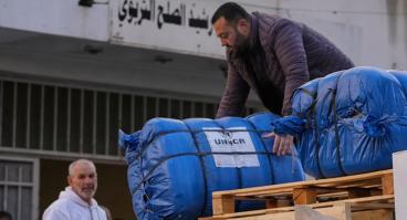  A man unloads humanitarian aid supplied by the U.N. refugee agency UNHCR at a school in Beirut used as a shelter for people displaced by Israeli airstrikes.