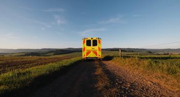 Yellow ambulance on a dirt road: medical transport in rural area