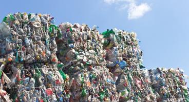 Stack of plastic bottles for recycling against blue sky
