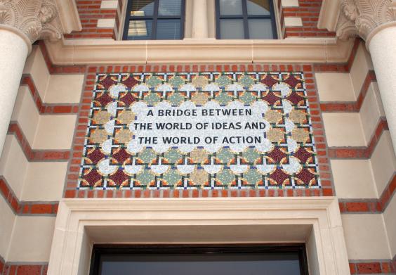 Tile mosaic over an entrance to Baker Hall that reads "A Bridge Between the World of Ideas and the World of Action"