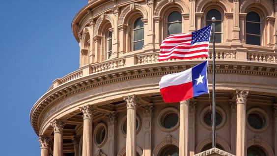 A close-up of the Texas Capitol building and the U.S. and Texas flags.