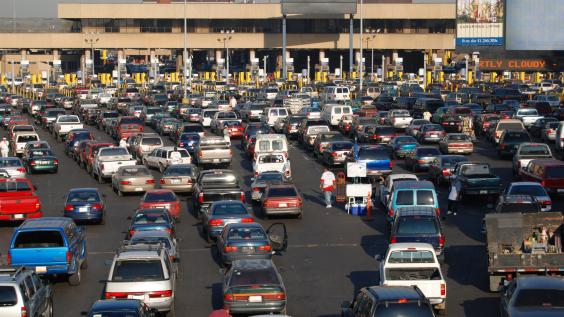 Multiple rows of cars lined up at the US-Mexico border. 