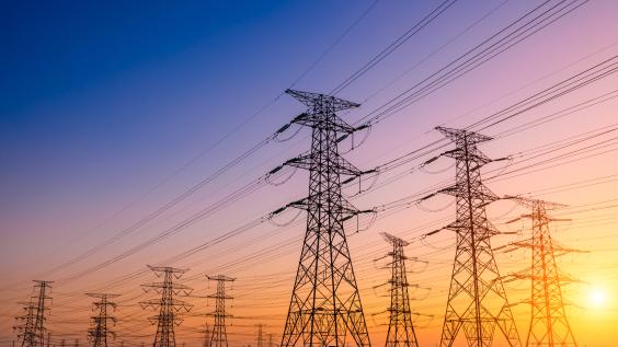 Transmission towers against a sunset.